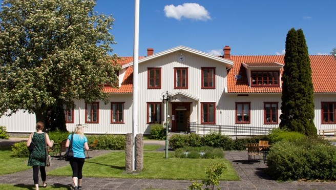 Två kvinnor  går mot Billströmska folkhögskolan entré.