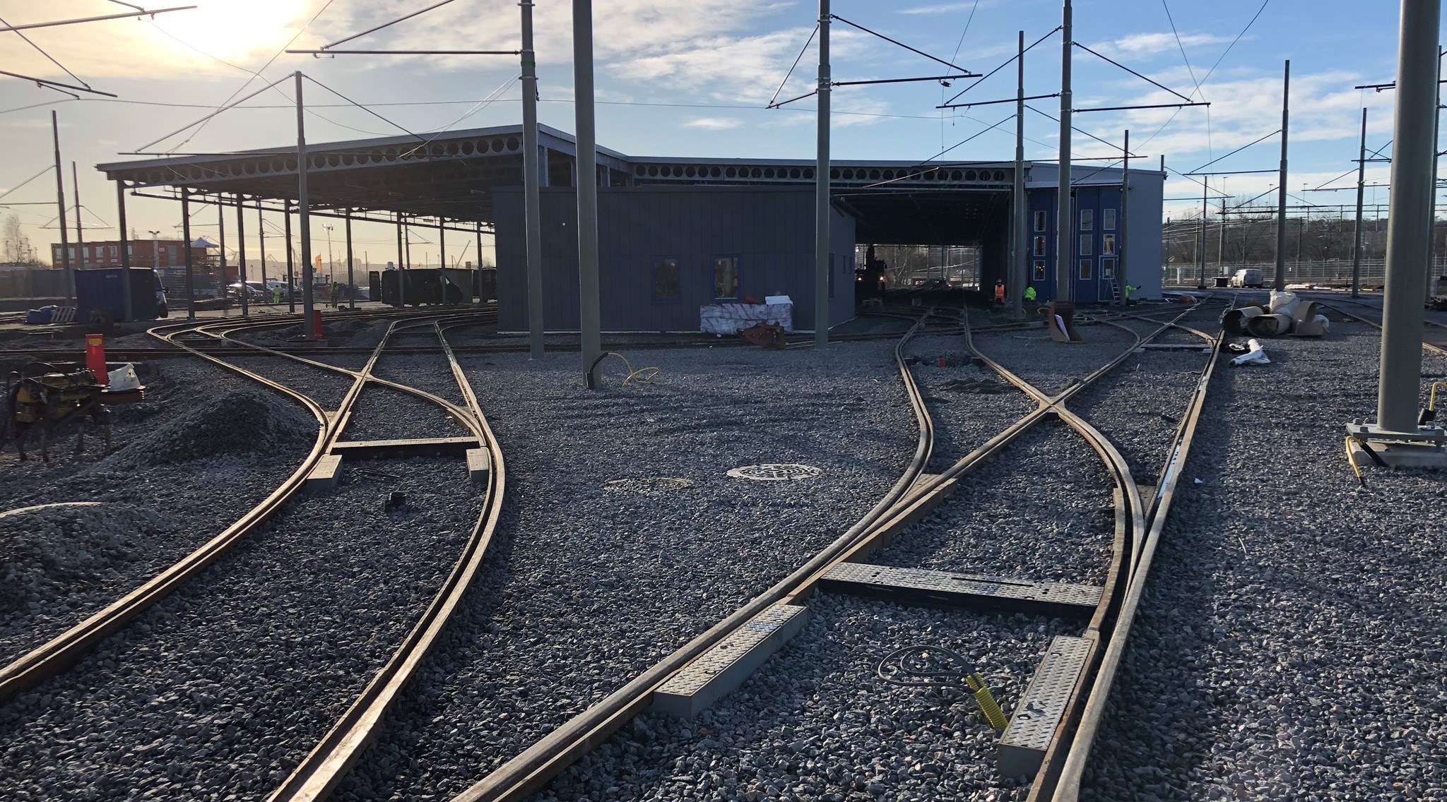 Två spår leder fram till en spårvagnsdepå längre bort.