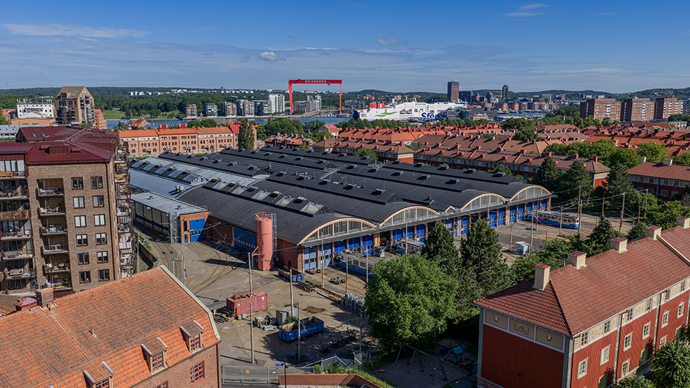 Vagnhallen Majorna med sitt välvda tak och röda tegel med älven och stadsdelen Eriksberg i bakgrunden